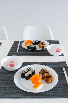 Fresh sushi and rolls in a white plate. Sushi lunch.