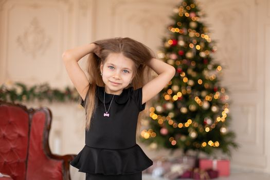 A little girl opens a Christmas present from Santa. Christmas tale. Happy childhood.