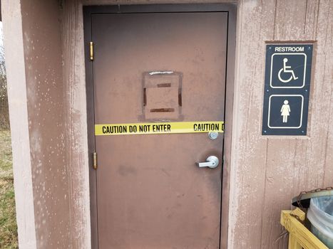 yellow caution tape do not enter sign on bathroom or restroom door