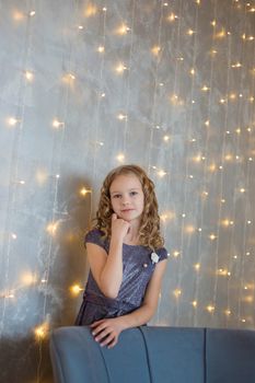 .Portrait of a cute girl on the background of Christmas garlands.