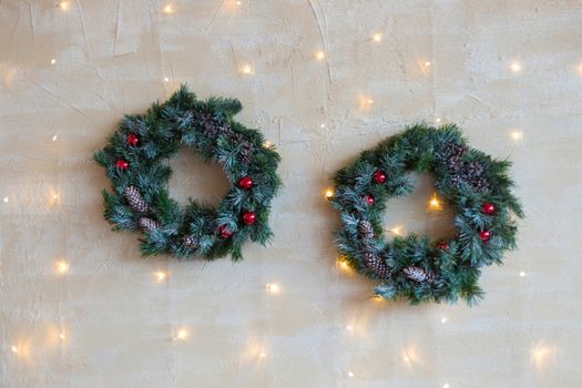 .Christmas wreaths with a Christmas tree on the background of Christmas garlands on the wall