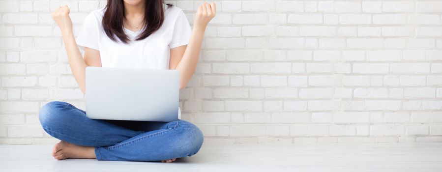 Banner website asian young woman excited and glad of success with laptop computer, girl sitting working on cement brick background, career freelance business concept.