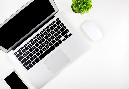 Top view of laptop computer with open display screen monitor, mouse and smart mobile phone and tree isolated on white background, communication technology on work office concept.