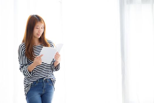 Beautiful of portrait young asian woman relax standing reading book on bedroom at home, girl study literature, education and lifestyle concept.