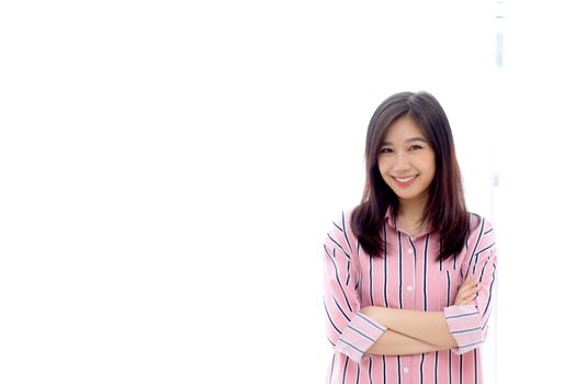 Portrait of beautiful young asian woman standing the window and smile while wake up with sunrise at morning, lifestyle and relax concept.