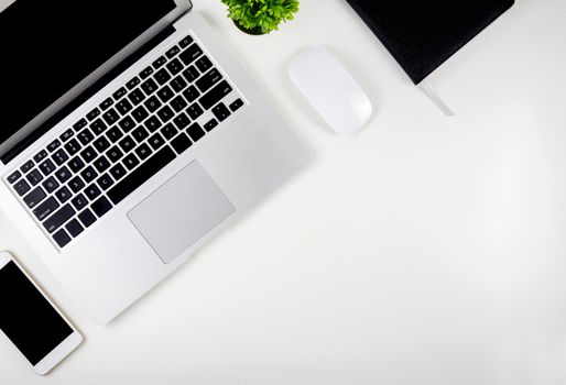 Top view of laptop computer with open display screen monitor, mouse and notepad and book and smart mobile phone isolated on white background, communication technology on work office concept.