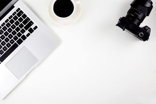Top view of laptop computer with open display screen monitor and coffee and camera isolated on white background, notebook or netbook with keyboard work on desk office, communication technology concept.