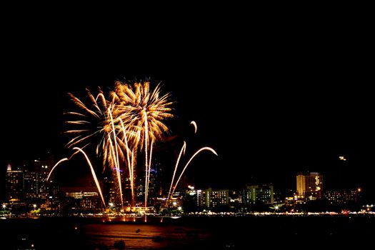 Many flashing fireworks with night cityscape background celebrate New Year.