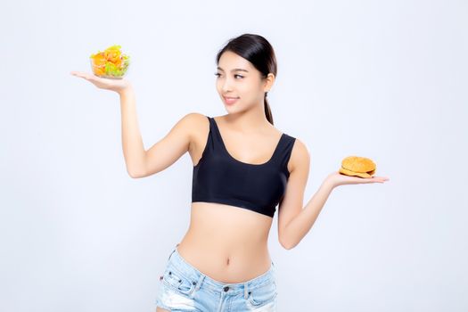 Beautiful young asian woman slim shape with diet choosing fresh salad vegetable and hamburger isolated on white background, food healthy with control for weight loss with calories, nutrition and lifestyle concept.