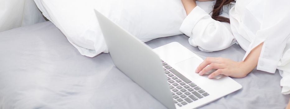 Banner website beautiful young asian woman with laptop lying down in bedroom, girl tired sleep with computer notebook, resting and healthcare concept.