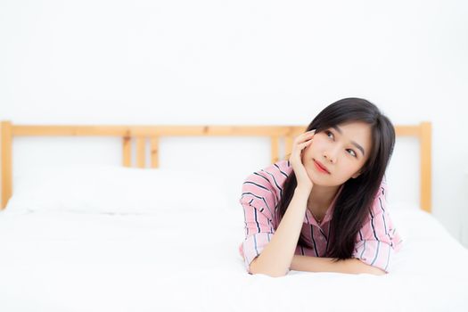 Beautiful portrait young asian woman lying and smile while wake up with sunrise at good morning, girl with happy, lifestyle and relax concept.