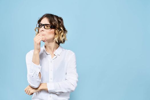 Business woman in a light shirt on a blue background gestures with her hands emotions model work. High quality photo