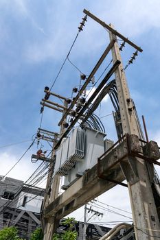 Transformer on electricity post on blue sky background.