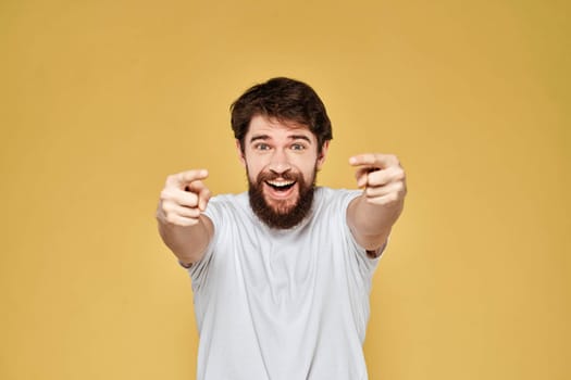 Bearded man on emotions white t-shirt fun lifestyle yellow background. High quality photo