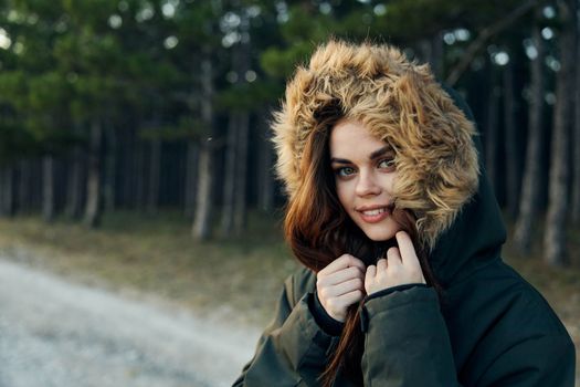 Pretty woman warm hooded jacket on nature close-up attractive look. High quality photo