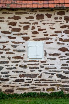 White window with wooden shutter in a colonial Pennsylvania stone wall with copy space.