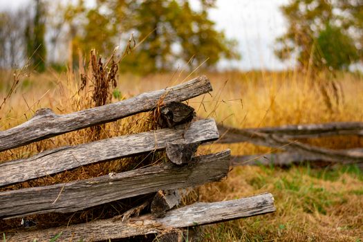 A Simple Old Wooden Fence With an Orange Field Behind It