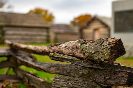 A Close-Up Shot of a Wooden Fence With Revoluationary War Era Replica Log Huts Behind it At Valley Forge National Historical Park