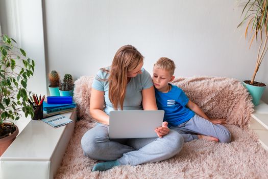 Mother with kid trying to work from home during quarantine. Stay at home, work from home concept during coronavirus pandemic