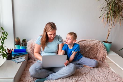 Mother with kid trying to work from home during quarantine. Stay at home, work from home concept during coronavirus pandemic