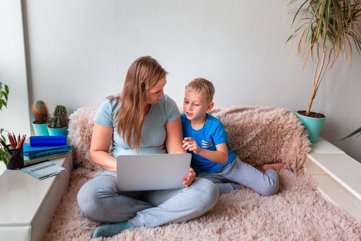 Mother with kid trying to work from home during quarantine. Stay at home, work from home concept during coronavirus pandemic