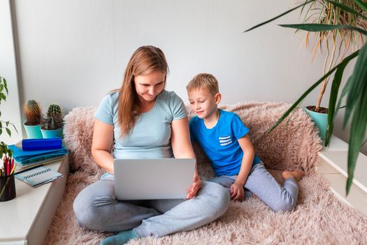 Mother with kid trying to work from home during quarantine. Stay at home, work from home concept during coronavirus pandemic