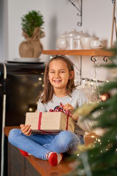 Little girl opens a box with a Christmas present from Santa.