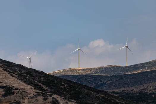 Hilly landscape with wind turbines at the westcoast of Rhodes island, Greece on a sunny day
