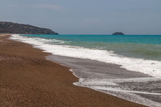 Gravel / pebble beach at the westcoast of Rhodes island near Kattavia with ocean waves and turquoise water