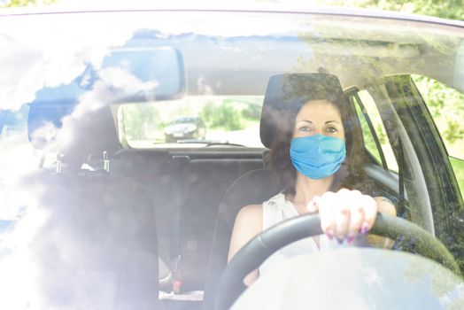 Beautiful young cheerful women with protective surgical mask looking at camera