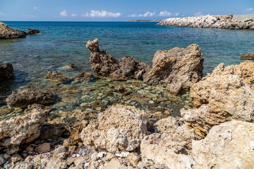 View at the rocky coastline of Plimmiri on  Rhodes island, Greece with gravel beach and rocks in the water