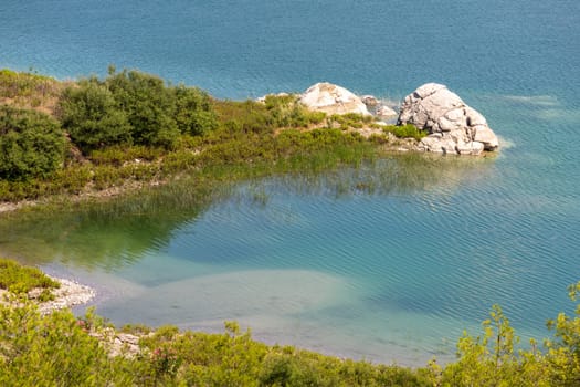 Scenic view at the Gadoura water reservoir on Rhodes island, Greece with blue and turquoise water and green landscape around the lake on a sunny day in spring