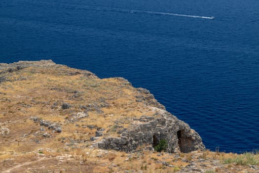 Coastline at Lindos on Greek island Rhodes with rocks in the foreground and the mediterranean sea in the background