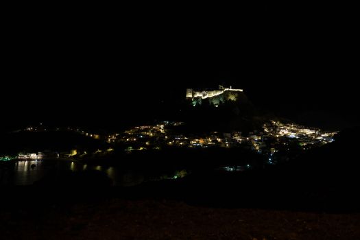 View at the illuminated city of Lindos and the acropolis on Greek island Rhodes by night