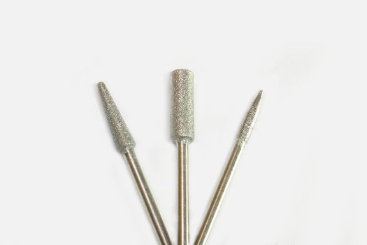 Set of three milling cutters. Manicure tool. Used manicurist professional tools on a white background.