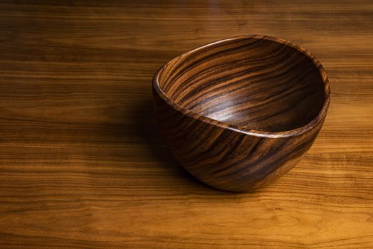 Bowl lying on a desk. Both created from walnut tree wood