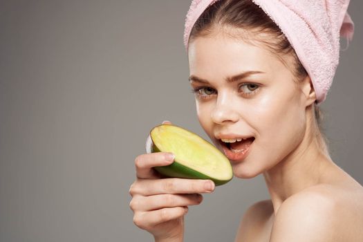 Cheerful woman eating mango vitamins bare shoulders health. High quality photo