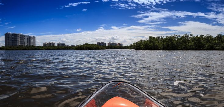 Clear see-through kayak forges its way through the waters of Delnor-Wiggins pass in Bonita Springs, Florida.