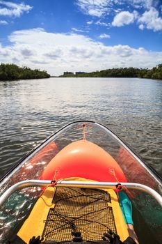Yellow, waterproof backpack inside a Clear see-through kayak forges its way through the waters of Delnor-Wiggins pass in Bonita Springs, Florida.