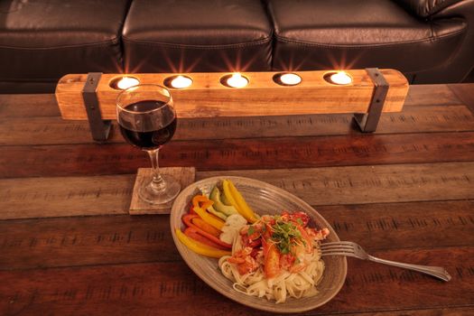 Red wine with Maine lobster over a bed of linguini with micro greens, colorful peppers and avocado sauce.