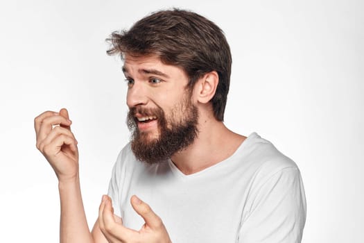 cheerful emotional bearded man gesturing with his hands close-up light background. High quality photo