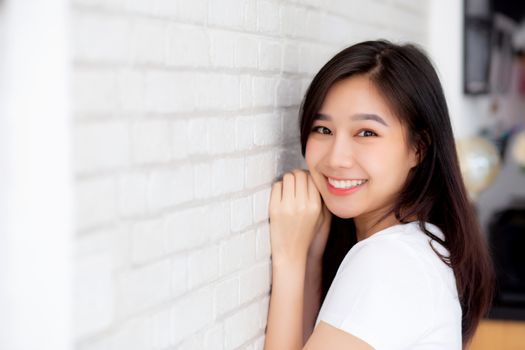 Portrait of beautiful young asian woman happiness standing on gray cement texture grunge wall brick background, businesswoman is a smiling on concrete, business people concept.