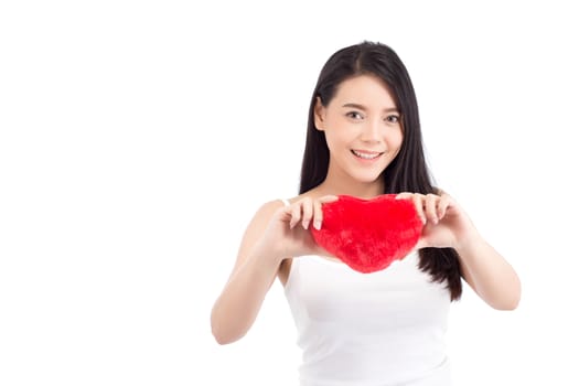 Portrait of beautiful asian young woman holding red heart shape pillow and smile isolated on white background, valentines day, holiday concept.