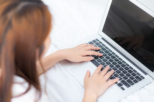 Closeup young asian woman using laptop for leisure on bedroom, girl working online with notebook freelance, business concept, top view.