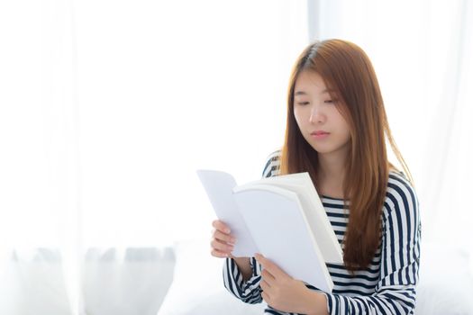 Beautiful of portrait young asian woman relax sitting reading book on bedroom at home, girl study literature, education and llifestyle concept.