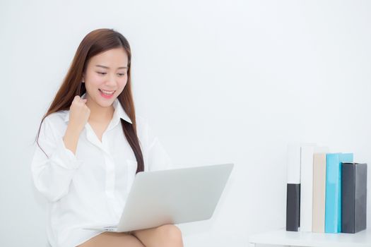 Beautiful of portrait happy young asian woman using laptop work with success on chair in the home, girl and notebook shopping online with glad, communication concept.