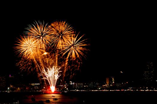 Many flashing fireworks with night cityscape background celebrate New Year.