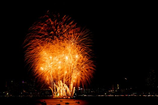 Many flashing fireworks with night cityscape background celebrate New Year.