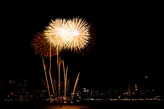 Many flashing fireworks with night cityscape background celebrate New Year.