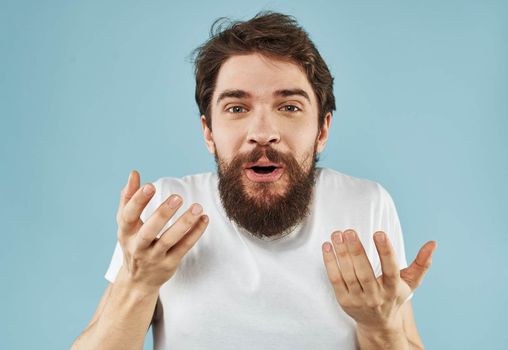 Puzzled man with a beard on a blue background emotions of surprise. High quality photo